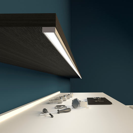 matala LED-profiili LED-nauhalle valaisemassa tumman puupinnan yläpuolella.