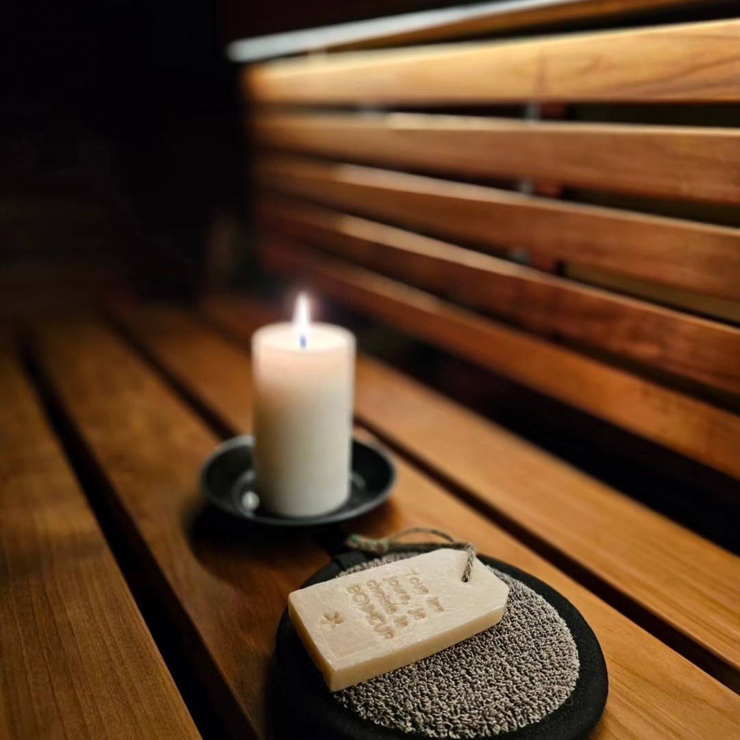 Pisteetön sauna led-valonauha, kynttilä ja saunatuotteet puupinnalla saunassa.