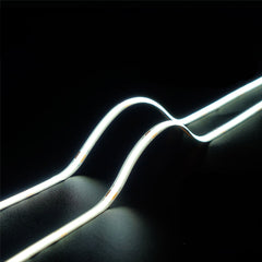 pisteetön COB LED-valonauha 24V näyttäen tasaisen valon kaarevia viivoja tummalla taustalla.