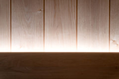 Sauna LED-valaistuspaketti, jossa valaistus näkyy puupaneelien yläpuolella.