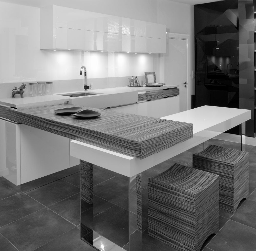 Modern kitchen interior featuring sleek white cabinets, a striped table island, and stylish stools.