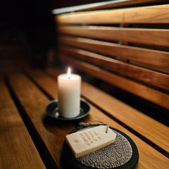 Pisteetön sauna led-valonauha, kynttilä ja saunatuotteet puupinnalla saunassa.