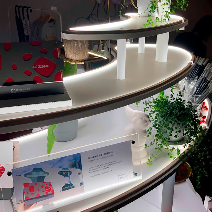 Tyylikäs esittelypöytä, jossa on LED-valonauhaa ja viherkasveja, esittelee 2019 kalenteria.